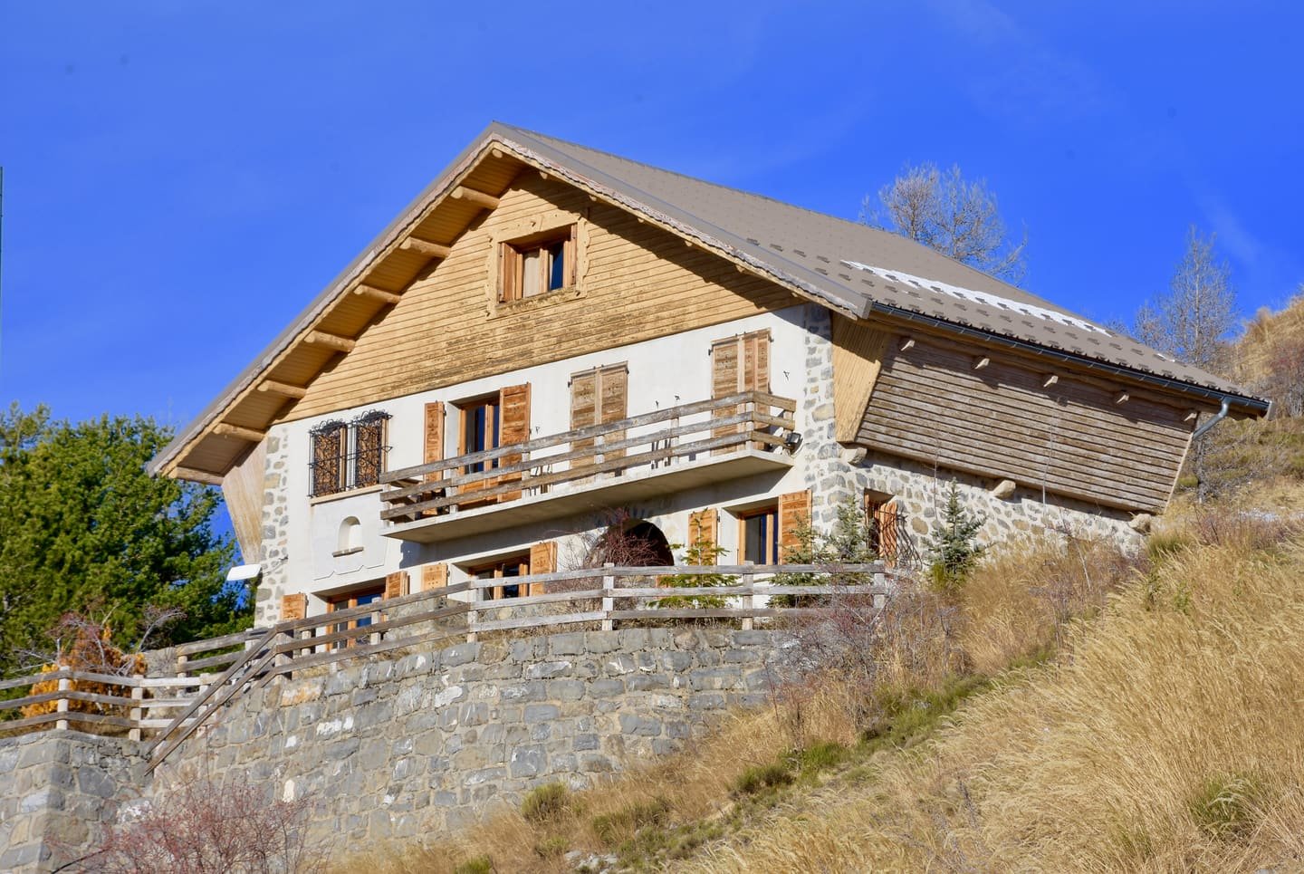 A stone and timber alpine chalet on a hillside