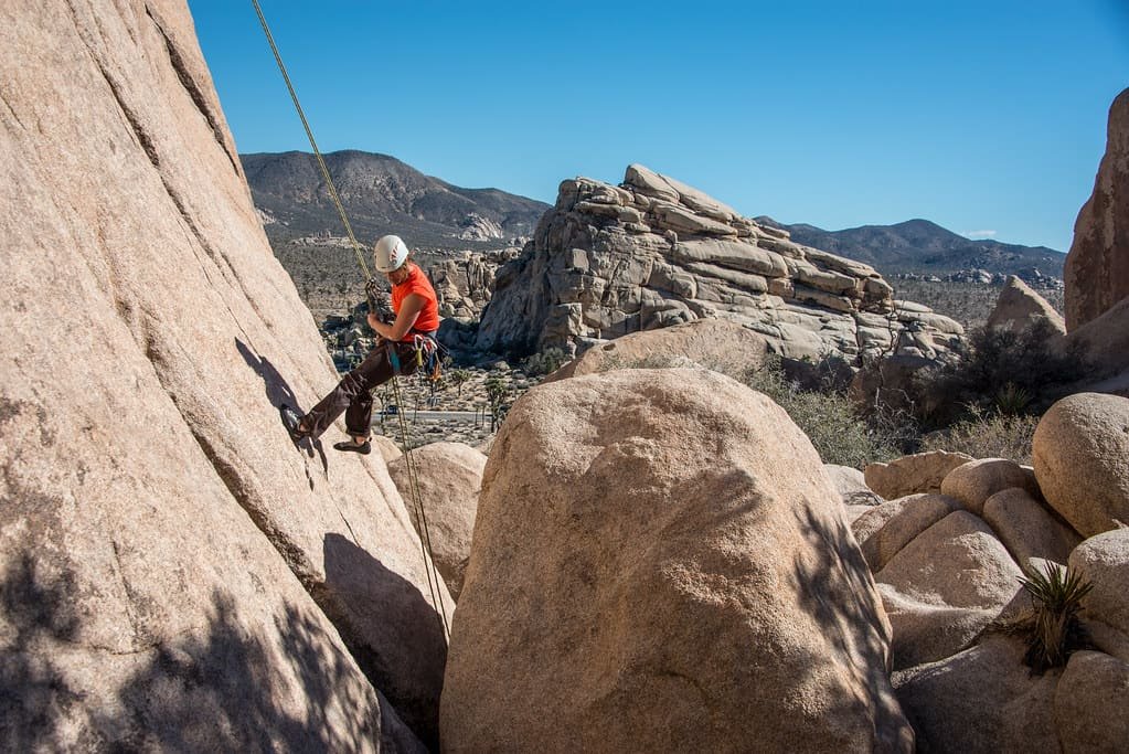 Un arrampicatore su una placca di granito, sotto il cielo aperto