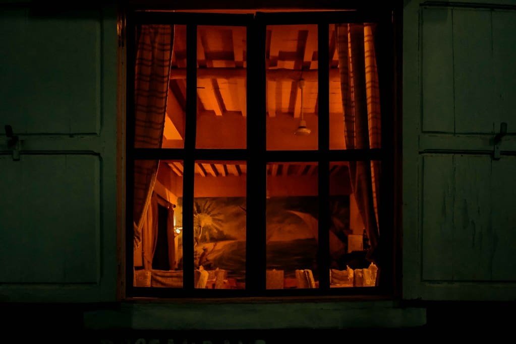 A warmly lit window at night in a timber building