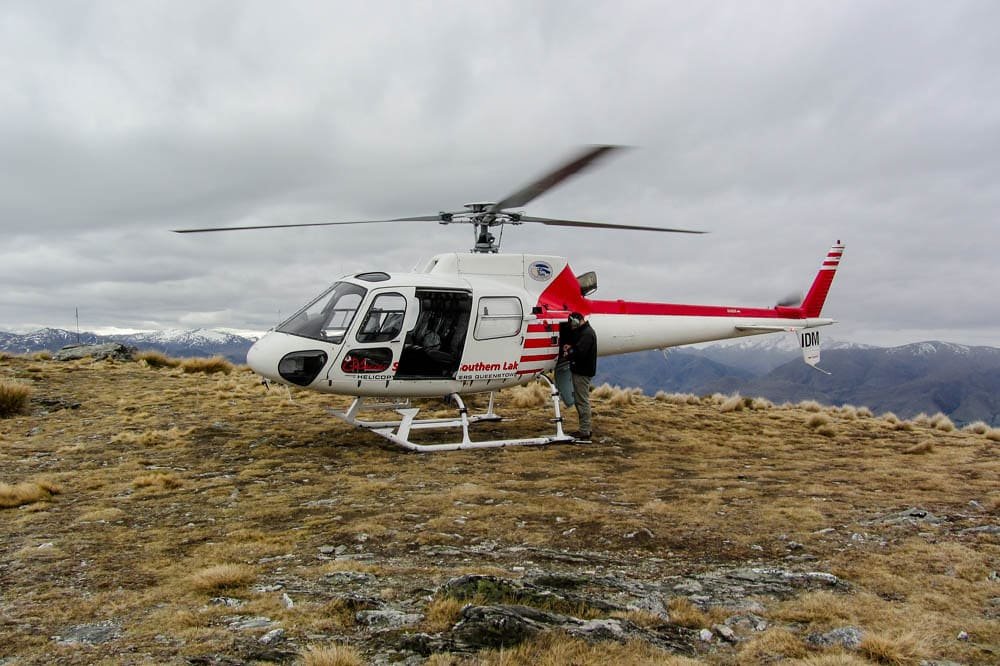 Un elicottero fermo su una piazzola in montagna