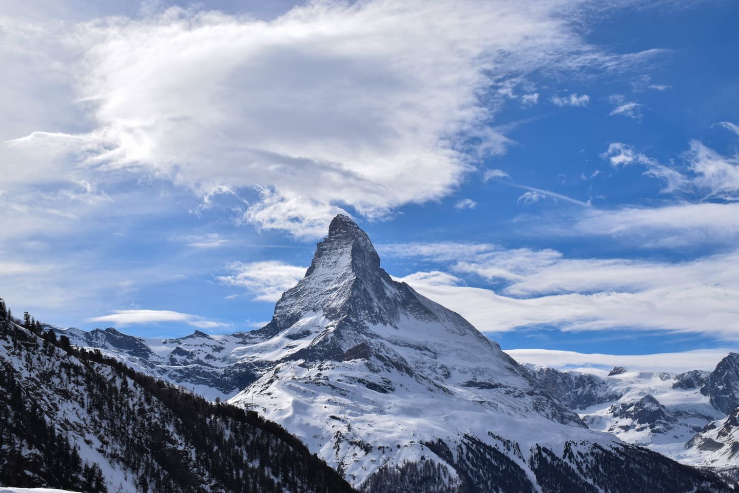 The Matterhorn standing clear above snow-covered slopes under a blue sky
