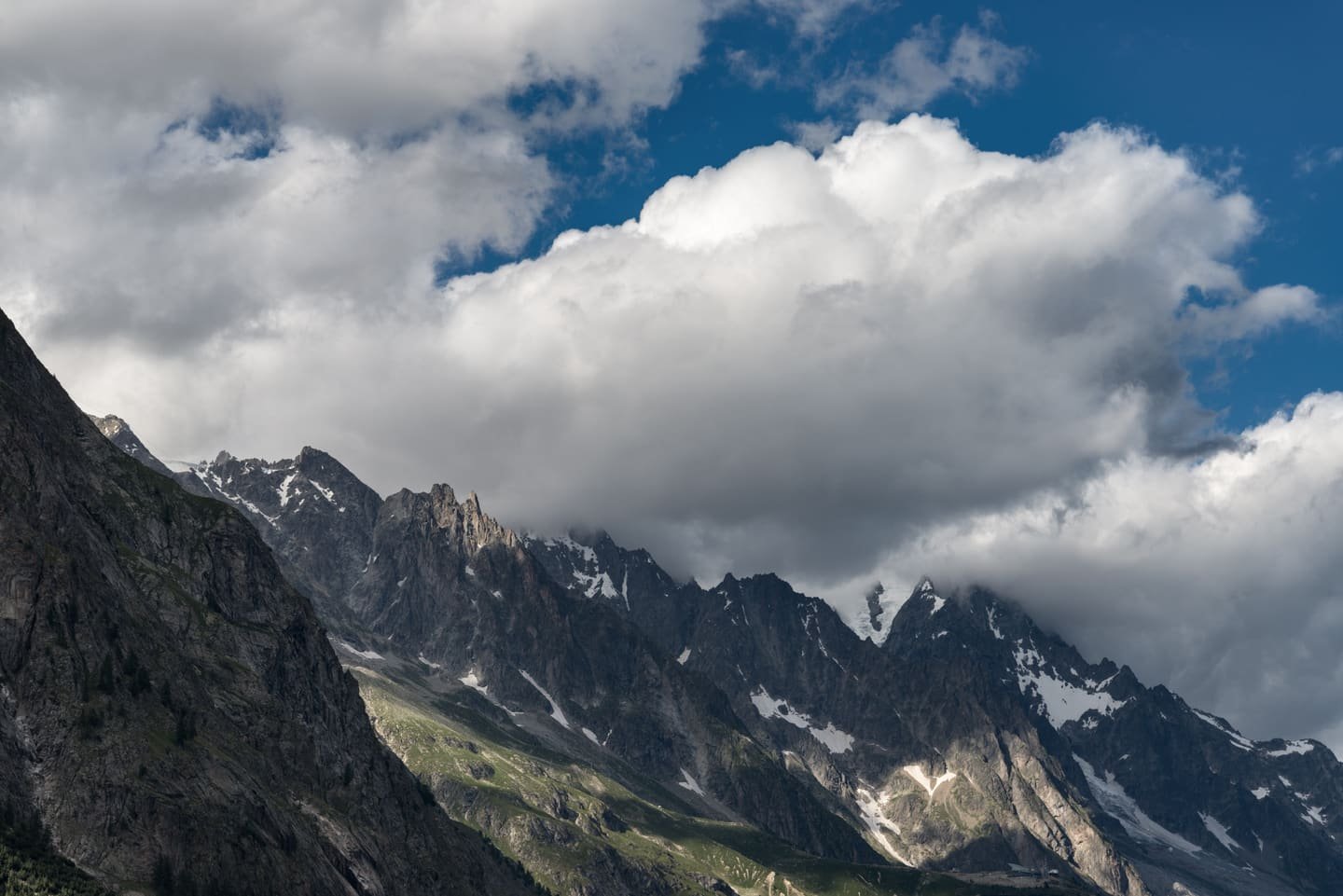 A dark rock summit of the Mont Blanc massif wreathed in cloud