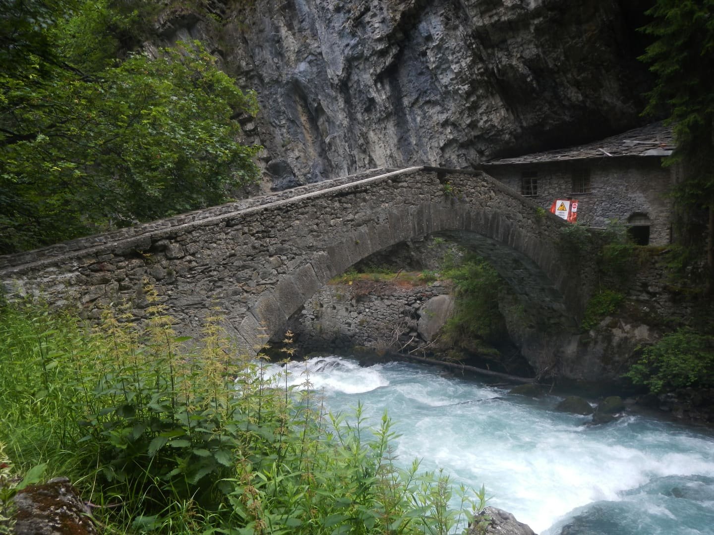 Un ponte di pietra sopra una gola stretta e l’acqua bianca che ci corre dentro