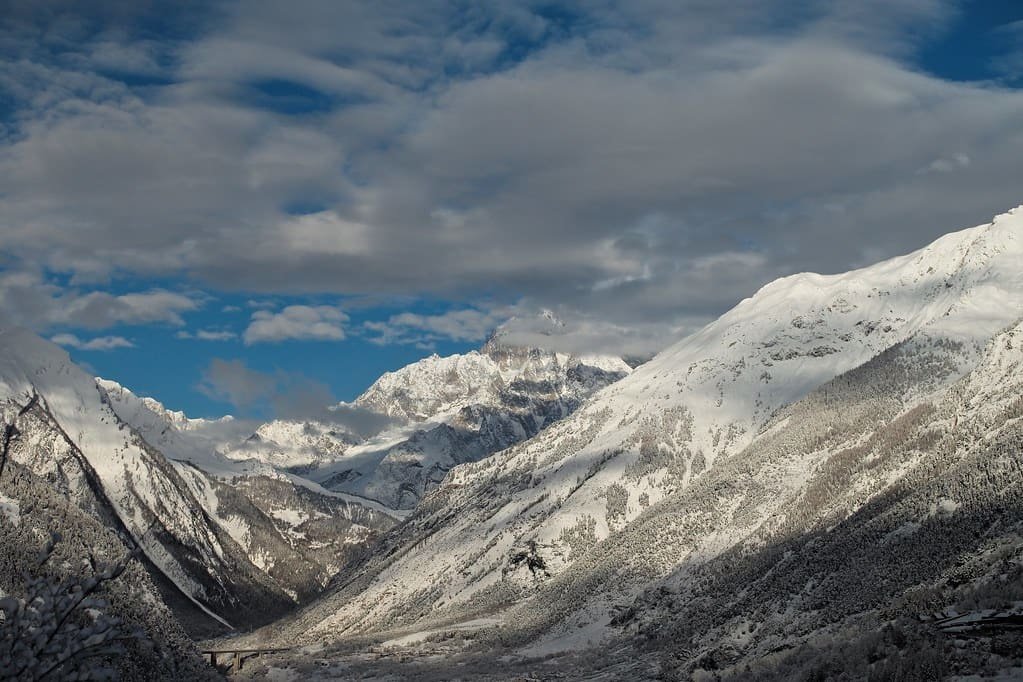 A snow-filled side valley under high peaks