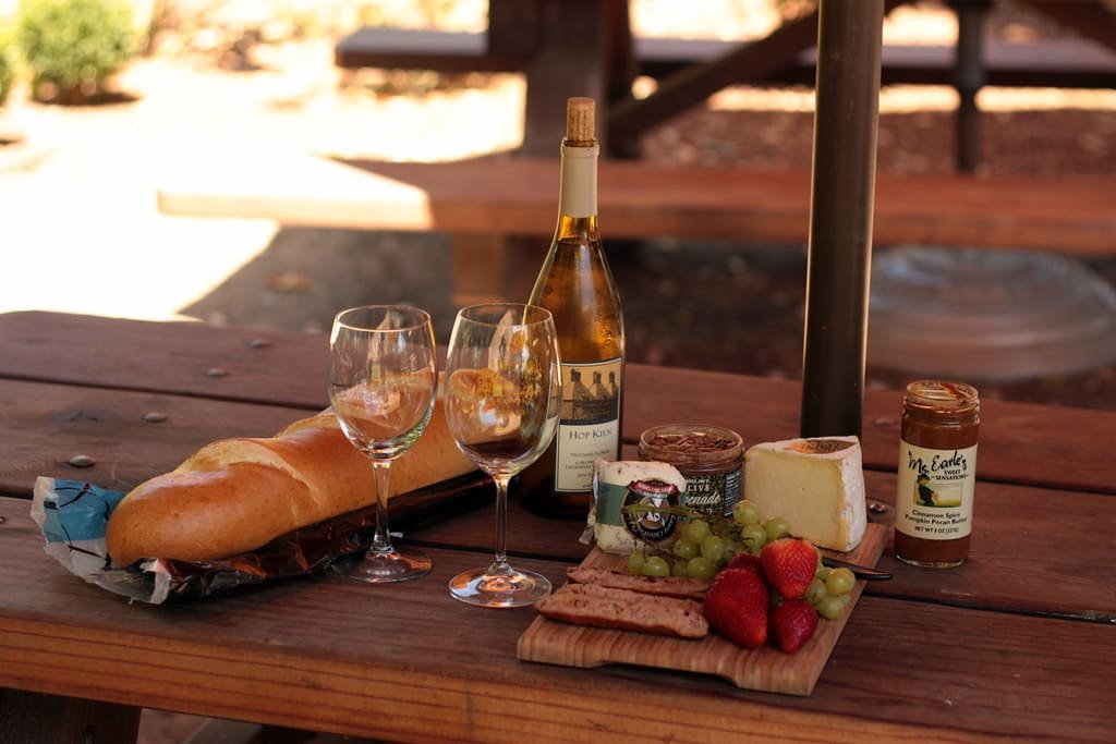 Glasses, bread and cheese set out for a tasting on a wooden table